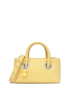 Piccola borsa a mano in pelle gialla con due manici arrotondati, occhielli argentati, tracolla removibile e un piccolo ciondolo a forma di orsetto del marchio TOUS.