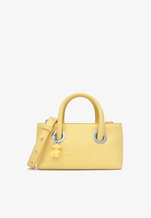 Piccola borsa a mano in pelle gialla con due manici arrotondati, occhielli argentati, tracolla removibile e un piccolo ciondolo a forma di orsetto del marchio TOUS.