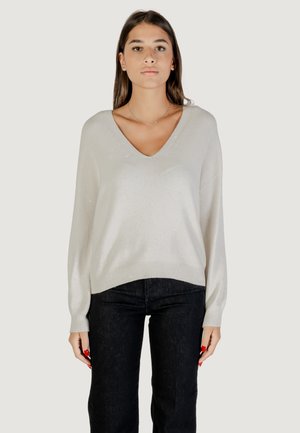 Maglione V-manica grigio chiaro con maniche lunghe, caratterizzato da una leggera lucentezza e orlo a costine, abbinato a jeans in denim scuro.