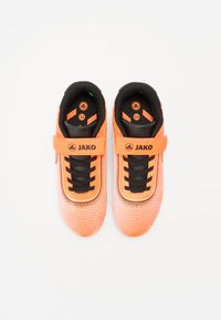 Oranžid spordijalatsid tekstuurse võrgu ülemise osaga, mustade aktsentidega ja Velcro rihmaga. Mustad nired ja logo keeltes. Suurus 34.