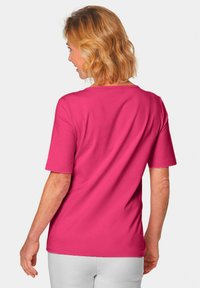 Helles pinkes T-Shirt mit kurzen Ärmeln und Rundhalsausschnitt, aus weicher Baumwolle gefertigt, mit einer lockeren Passform und glatter Textur.
