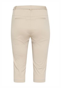 Pantalons beiges cropped avec une texture lisse, une taille élastique et deux poches arrière. Design simple sans motifs ni accents visibles.
