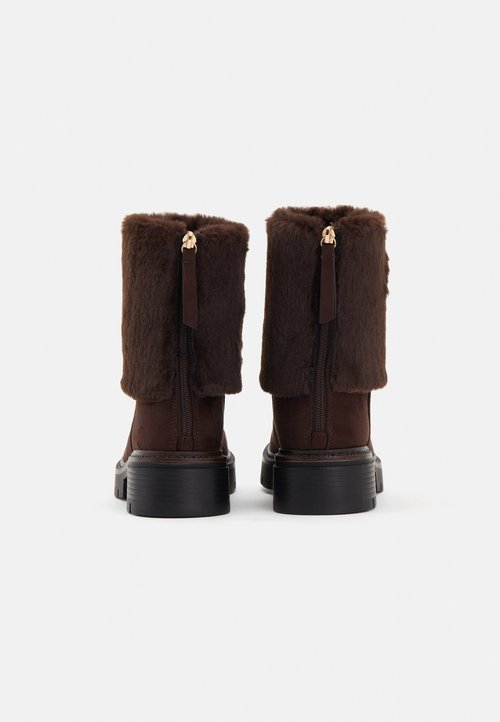 Brown ankle boots with faux fur cuffs, featuring black zippers and textured soles. The fur adds visual softness to the design.