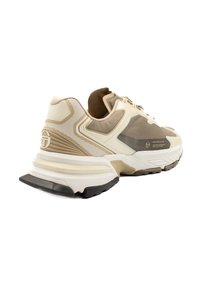 Beige och vit atletisk sneaker med en texturerad yta, släta överlager och en tjock svart yttersula; har branding på sidan.