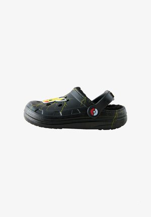 Schwarze Clogs mit einem Pikachu-Design, das gelbe Blitzmuster, ein kuscheliges Innenfutter und einen runden roten und weißen Knopf an der Seite zeigt.