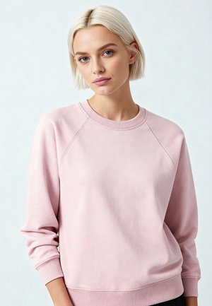 Felpa rosa chiaro con collo rotondo, maniche raglan e polsini e bordo a costine. Realizzata con un tessuto morbido e dalla texture.