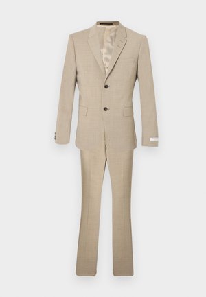 Μπεζ κοστούμι κατασκευασμένο από υφασμάτινη υφή, με σακάκι δύο κουμπιών, πέτο με εγκοπές και παντελόνια ραμμένα με ελαφριά φουσκώματα.