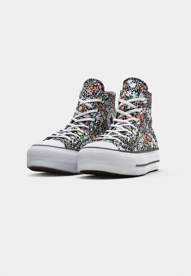 Baskets montantes avec un motif floral multicolore, semelle en caoutchouc blanche et design à lacets. Tissu texturé avec des accents ton sur ton.