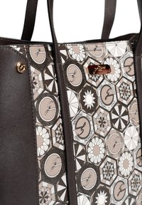 Brązowa skórzana torebka typu tote z wzorzystymi, beżowymi i białymi bokami. Posiada złotą tabliczkę z logo oraz geometryczne wzory, co nadaje teksturowy wygląd.