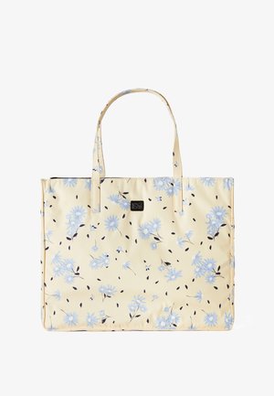 Kremowa torba typu tote z jasnoniebieskim kwiatowym nadrukiem i dwoma paskami na ramię, z małym czarnym prostokątnym logo na środku z przodu.