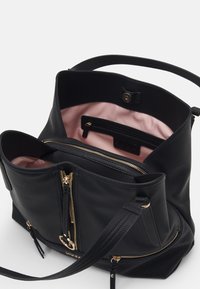 Borsa a mano in pelle nera testurizzata con interno in tessuto rosa chiaro, dettagli con cerniere dorate e una tasca esterna. Dotata di tracolla.