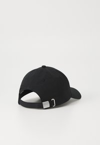 Svart baseball-cap med buet skjerm, laget av stoff. Har en metallspenne bak og sydd ventilasjonsøyler.