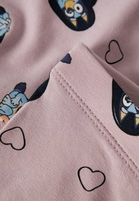 Roze stof heeft illustraties van cartoonpersonages en kleine hartjes, met een zachte textuur en een naadloze randafwerking.