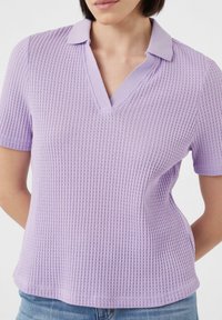 V-Ausschnitt Kurzarm-Top aus leichtem lila Strickstoff mit strukturiertem Waffelmuster. Verfügt über einen passenden Kragen und eine lockere Passform.