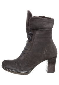 Bottine en daim gris avec bout arrondi, laçage sur le devant, doublure en fourrure moelleuse et talon bloc texturé. Des coutures décoratives soulignent le design.