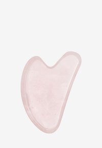 Heart-shaped gua sha tool made of translucent pink quartz, featuring smooth edges and a glossy surface, designed for skincare use.