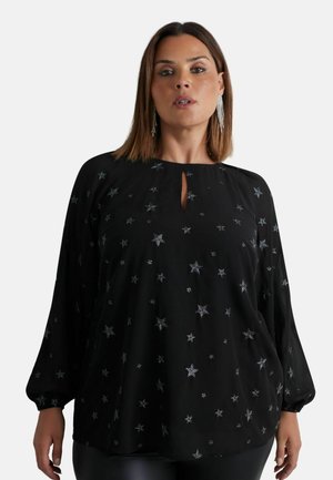 Blouse noire avec des manches longues, motif étoile en argent, détail en décolleté en trou de serrure et tissu fluide pour un ajustement décontracté.