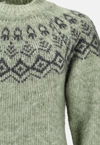 Pull en laine vert avec motifs géométriques et floraux noirs sur la poitrine et col côtelé haut.