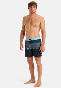 Shorts de bain pour homme dégradés du bleu au noir. Tissu à séchage rapide, taille à cordon de serrage et logo imprimé sur le devant.