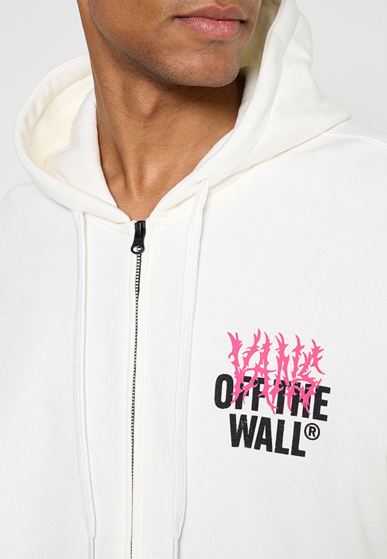 Biała bluza z zamkiem, wykonana z miękkiego materiału, z różowym wzorem graficznym i czarnym napisem "OFF THE WALL" na klatce piersiowej.