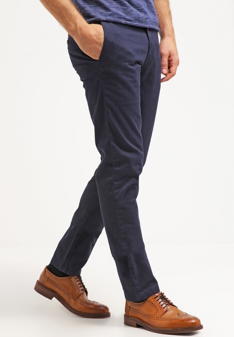 Námořnické kalhoty s úzkým střihem, vyrobené z bavlněné směsi. Obsahují boční kapsy a hladkou texturu. V kombinaci s hnědými koženými brogue.