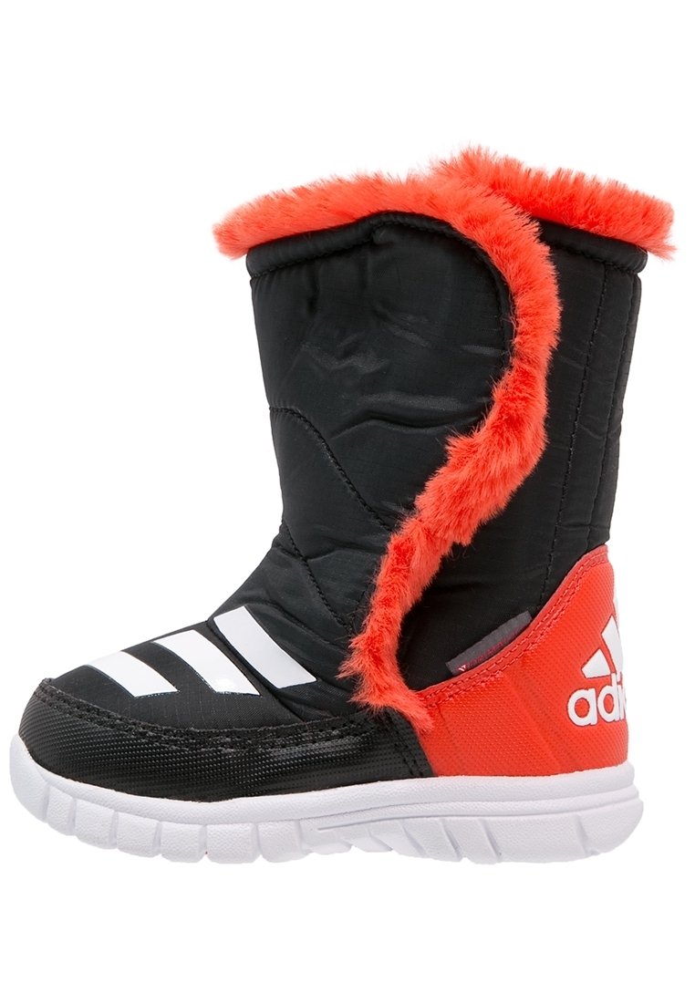 Czarno-czerwony but z puszystym czerwonym wykończeniem, górna część z tkaniny, białe paski i teksturowana gumowa podeszwa dla lepszej przyczepności.