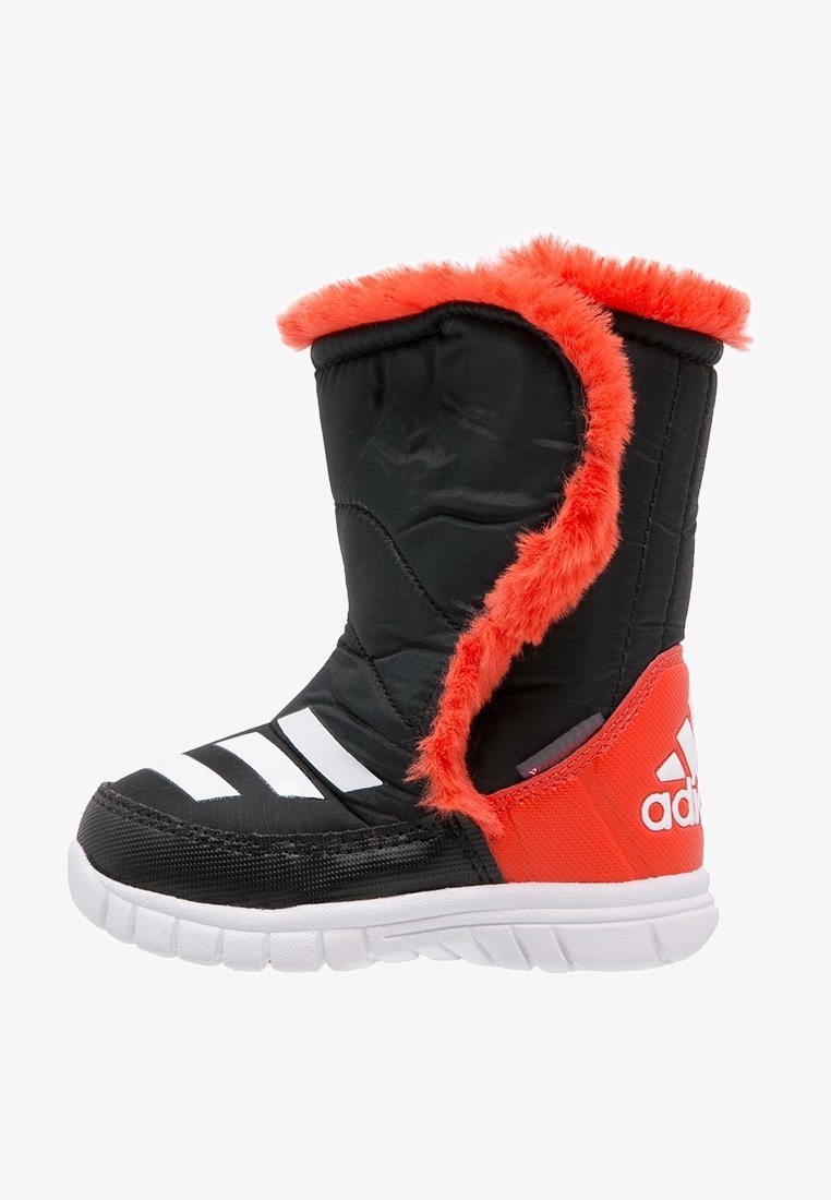 Czarno-czerwony but z puszystym czerwonym wykończeniem, górna część z tkaniny, białe paski i teksturowana gumowa podeszwa dla lepszej przyczepności.