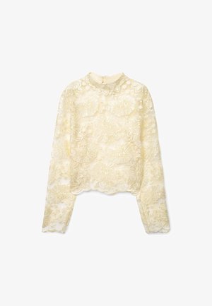 Top in pizzo a maniche lunghe color crema con ricamo floreale, orlo smerlato e collo alto. Presenta una chiusura con cerniera sul retro.