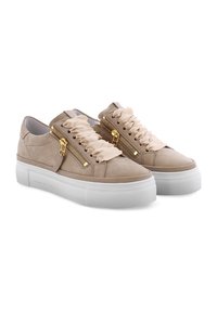 Helle beigen Wildledersneaker mit weißen Plateau-Sohlen, die zwei dekorativen goldenen Reißverschlüsse und cremefarbene Rüschenschnürsenkel aufweisen.