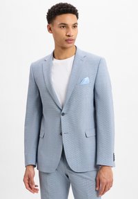 Lichtblauwe blazer met een gestructureerd patroon, twee knopen, notch revers en een pochet. Gecombineerd met een wit t-shirt eronder.