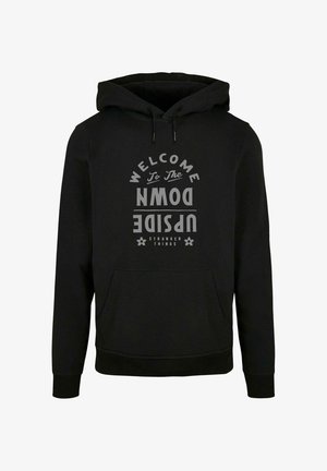 Čierna mikina s kapucňou, na ktorej sa nachádza veľký sivý grafický nápis "VITAJTE NA OPAČNEJ STRANE" a "STRANGER THINGS" s kvetinovými akcentmi, s vreckom typu klokanka.