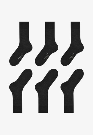 Μαύρες βαμβακερές κάλτσες με λεία υφή, με μήκος μέχρι τη μέση της γάμπας και ραμμένες μανσέτες. Λογότυπο εκτυπωμένο σε λευκό στη σόλα.