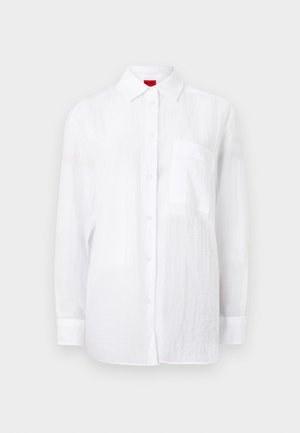 White long-sleeve shirt made of lightweight fabric, featuring a button-down front, collar, and a left chest pocket. Subtle textured finish.