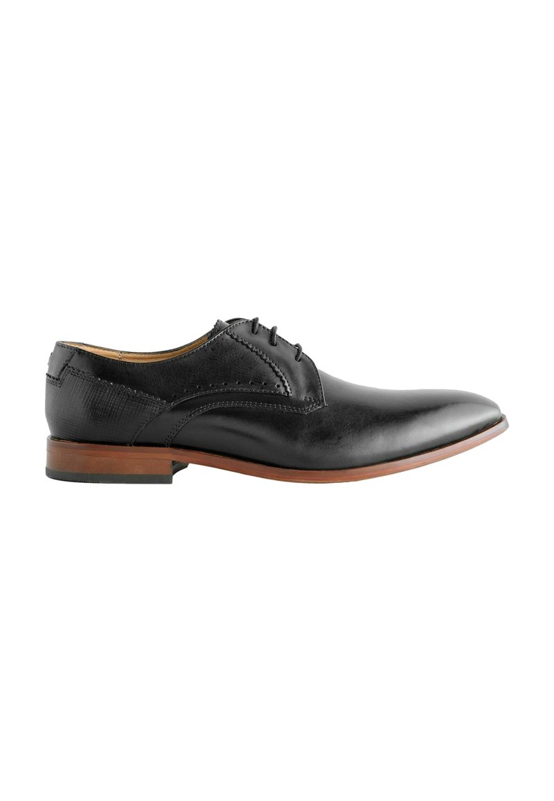 Zwarte leren dresschoen met een gladde afwerking, spitse neus, vijf veterogen en een bruine houten hak. Decoratieve brogue-details aan de zijkanten.