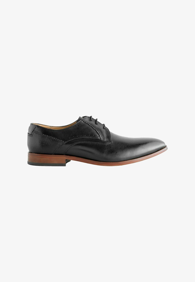 Chaussure de ville en cuir noir avec une finition lisse, embout pointu, cinq œillets et un talon en bois marron. Détails de brogue décoratifs sur les côtés.