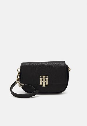 Sort tekstureret læder crossbody taske med guldkæde og guld TH-logo i lås på frontklappen.