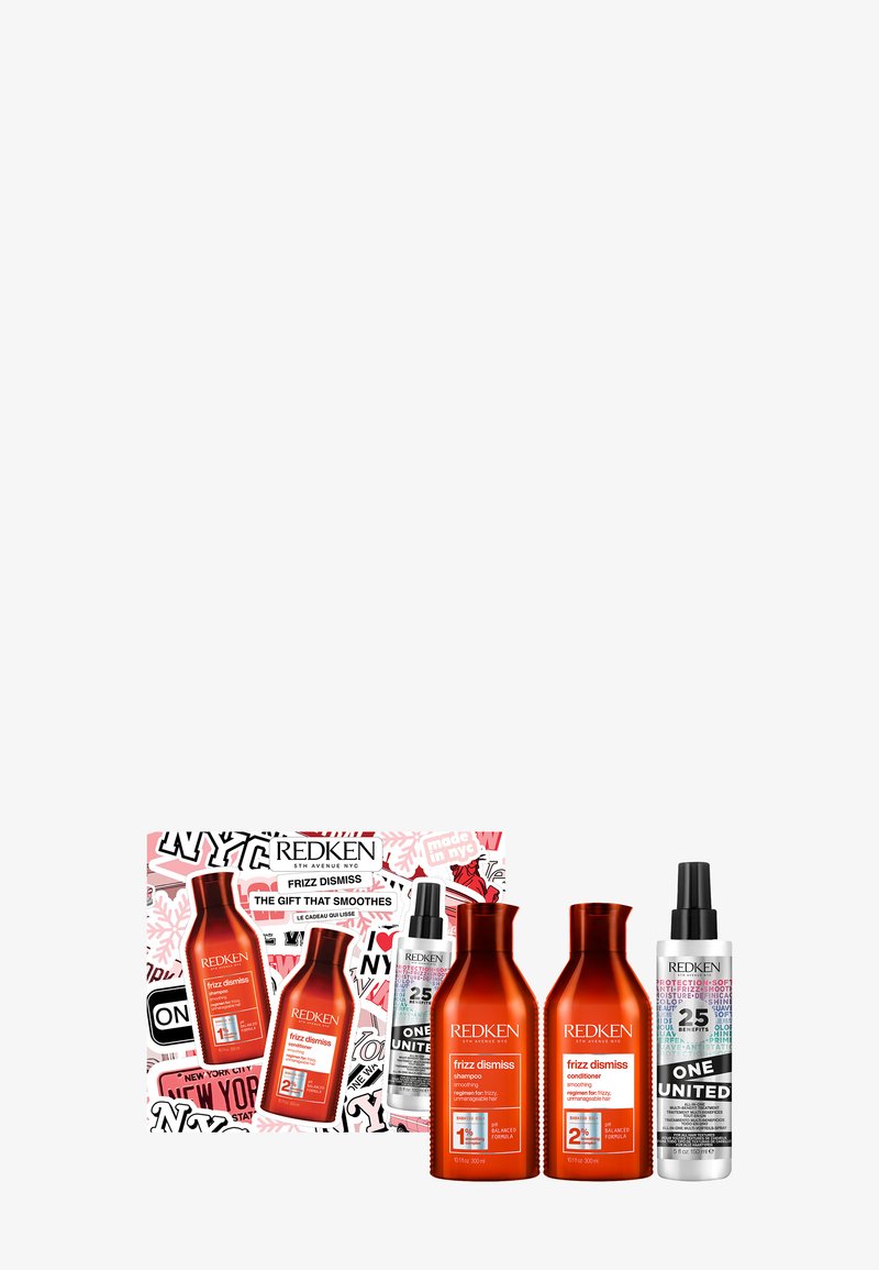 Set di quattro prodotti per capelli Redken: due flaconi di shampoo e balsamo arancioni, uno spray nero e uno spray trasparente, tutti in una confezione grafica.