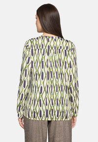 Bluzka z długim rękawem w kolorze kremowym z zielonym i fioletowym geometrycznym wzorem diamentowym, z karczkiem z tyłu i marszczonymi detalami.