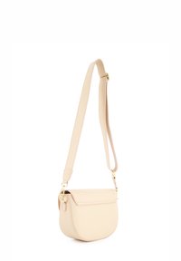 Beige Leder Umhängetasche mit runder Form, flacher Klappenverschluss, verstellbarem Riemen und goldenen Hardware-Akzenten. Glatte Textur.