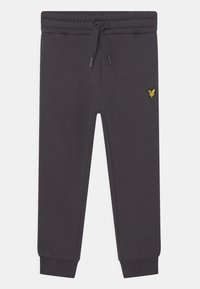 Mørkegrå sweatpants lavet af blødt materiale, med elastisk talje og snøre, ribbede mansjetter og et lille gult logo på siden.