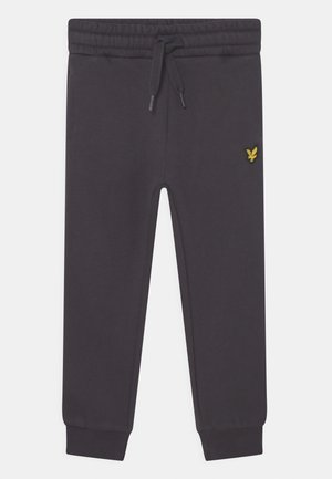 Mørkegrå sweatpants lavet af blødt materiale, med elastisk talje og snøre, ribbede mansjetter og et lille gult logo på siden.