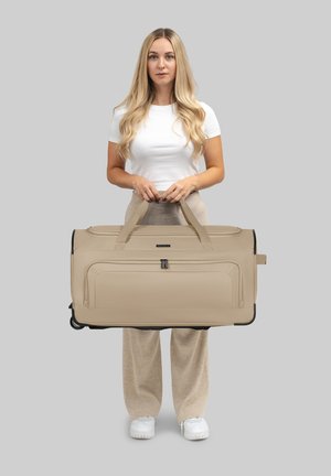 Borsa da ginnastica beige con ruote, dotata di doppi manici superiori, un esterno liscio, tasca di stoccaggio con cerniera e accessori neri.