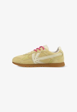 Beige suède sneaker met wit logodetail, roze veters en een bruine rubberen zool, gezien vanaf de linkerkant tegen een witte achtergrond.