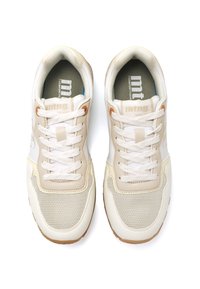 Zapatillas deportivas en color beige y blanco, con parte superior de malla, suela de goma y cierre de cordones, que presentan una ligera textura y acentos de logo en la lengüeta.