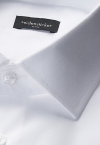 Witte overhemden met knopen, voorzien van een gestructureerde kraag, een gladde textuur en een zwart label met de merknaam "seidensticker uno".