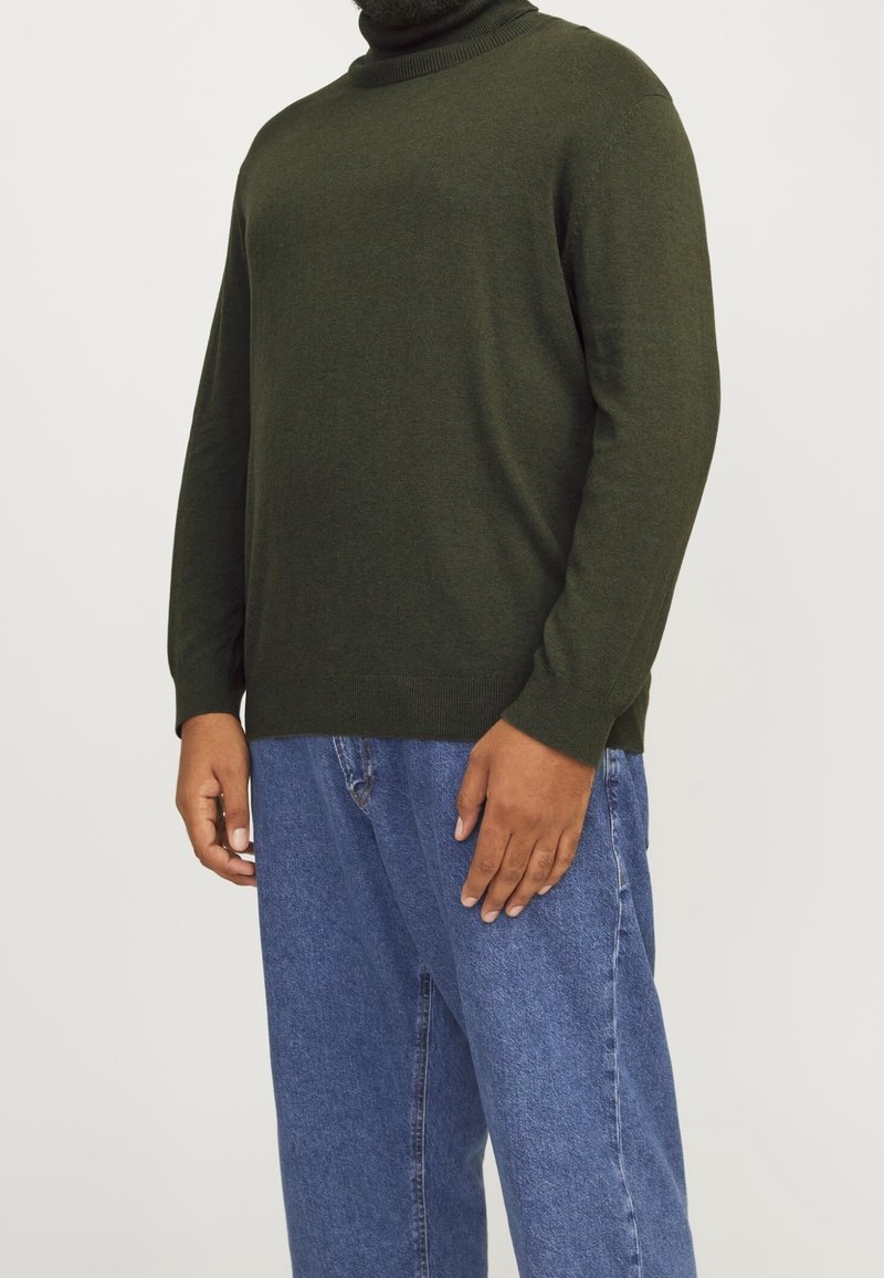 Ciemnozielony sweter z golfem wykonany z miękkiego dzianinowego materiału, z długimi rękawami i prążkowanym kołnierzem, w zestawie z jasnoniebieskimi dżinsami.