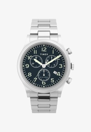 Roostevabast terasest kell musta kullaga, suured araabia numbrid, kroonograafi alad, hõbedased käed ja kuupäeva näidik kell 6.