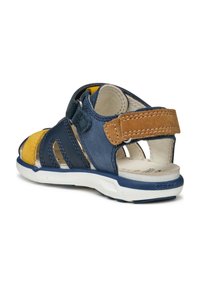 Kožené sandály pro malé děti v navy modré a žluté barvě s třemi výřezovými pruhy, suchým zipem a bílou podrážkou se strukturovanými akcenty.