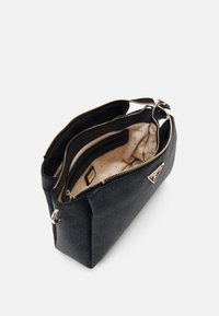 Black textured handbag with gold-tone hardware, featuring dual zip compartments and a beige interior with logo patterns and pockets.