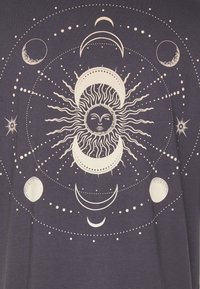 Dunkelviolettes T-Shirt mit einem zentralen Sonnenmotiv, umgeben von Monden und Sternen in Weiß, mit feinen Details und kreisförmigen Mustern.
